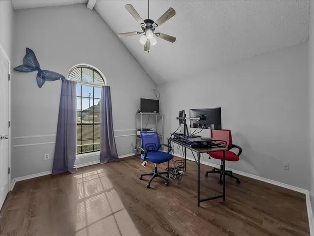 a workspace with wooden floor and a chandelier fan