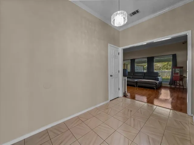 wooden floor with chandelier and glass door