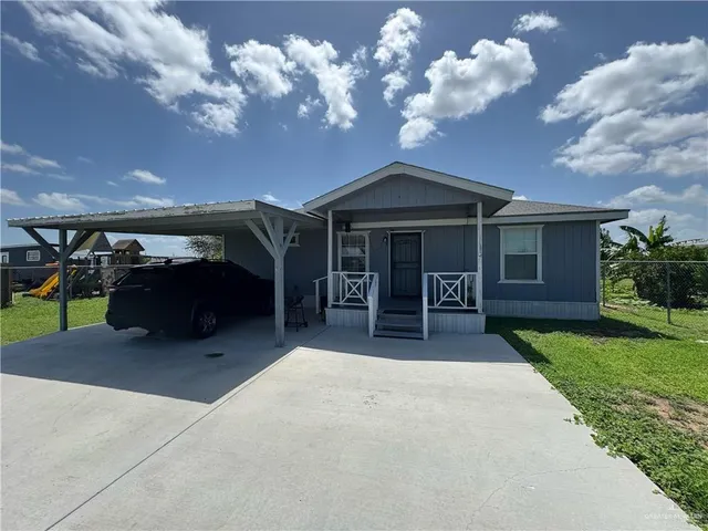 a view of a house with porch and a yard