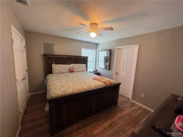 a bed sitting in a bedroom next to a window and a chandelier