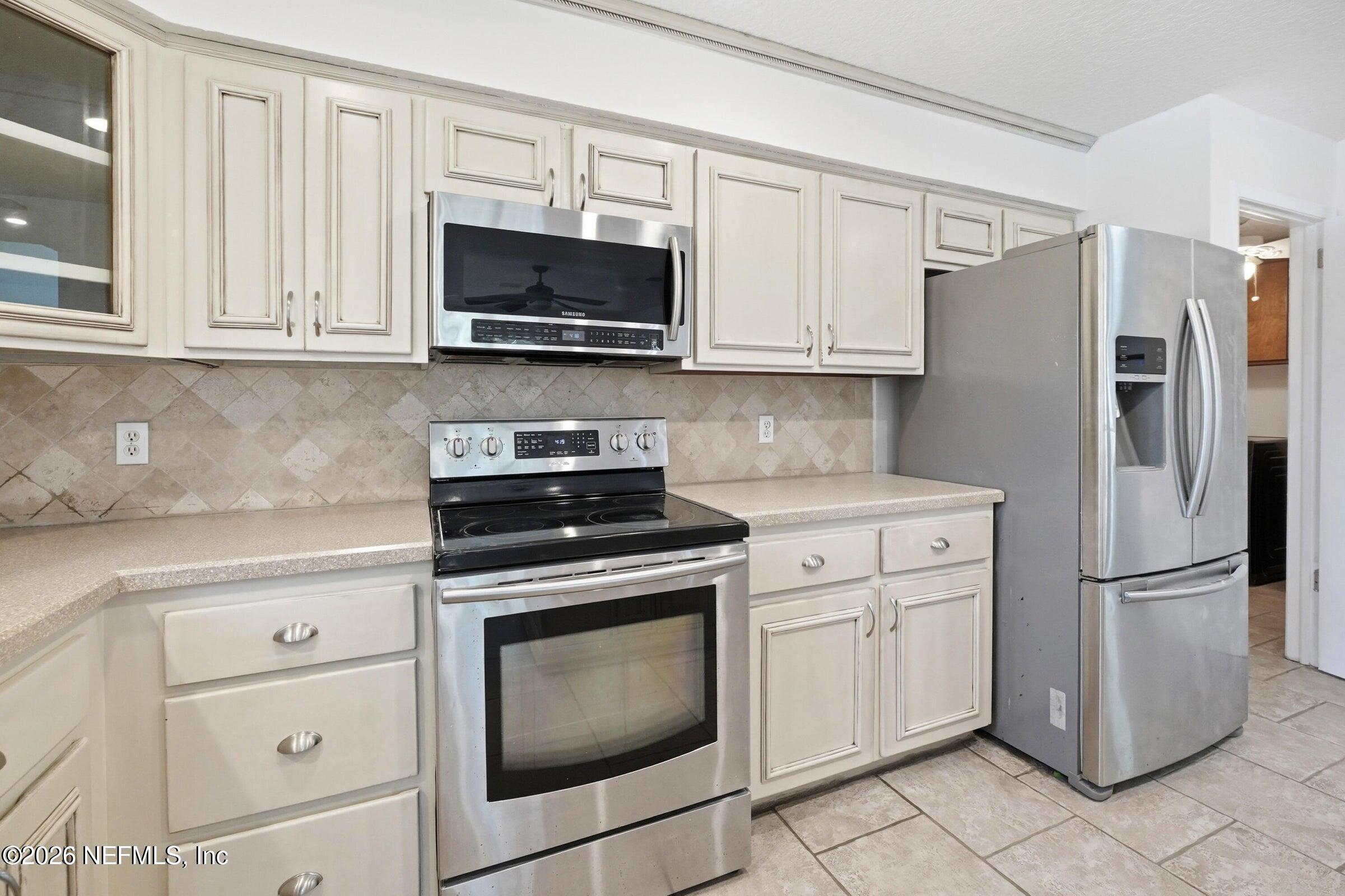 969 Alpine Ridge Court Orange Park, FL 32065 - Photo 11 of 26 a kitchen with white cabinets and stainless steel appliances