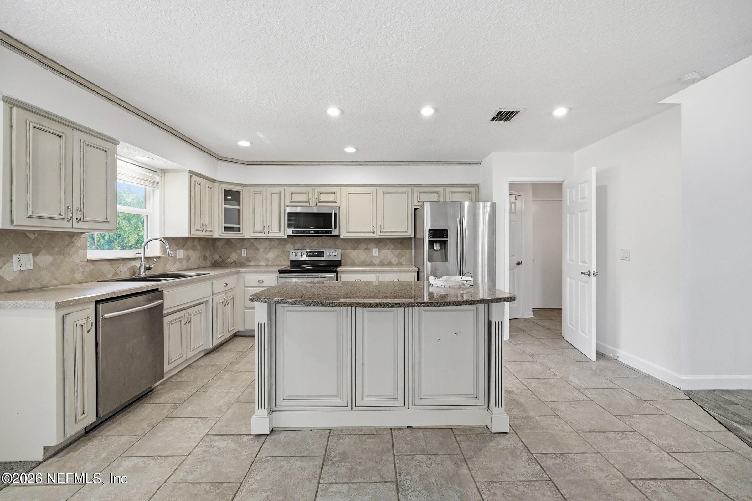 969 Alpine Ridge Court Orange Park, FL 32065 - Photo 3 of 26 a kitchen with stainless steel appliances granite countertop a refrigerator sink and cabinets