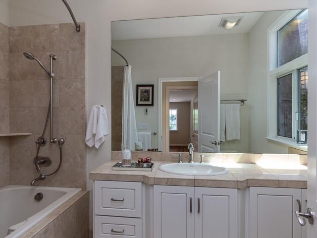 79 Del Prado Drive Campbell, CA 95008 - Photo 29 of 34 a bathroom with a granite countertop sink a mirror a bathtub and shower