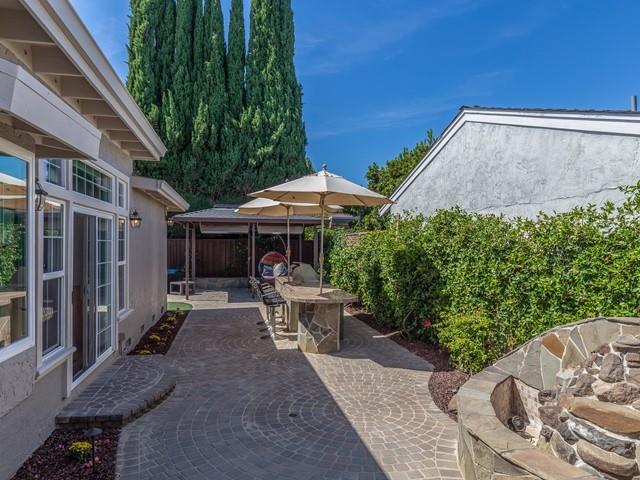 79 Del Prado Drive Campbell, CA 95008 - Photo 30 of 34 a backyard of a house with table and chairs under an umbrella