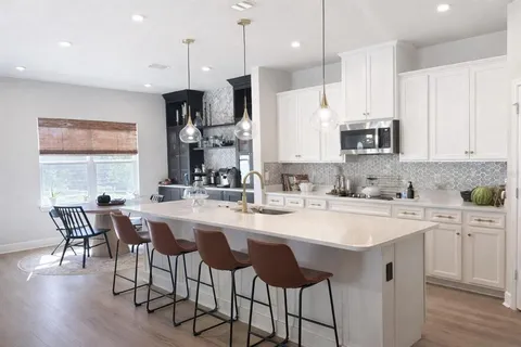 a kitchen with appliances a sink and cabinets