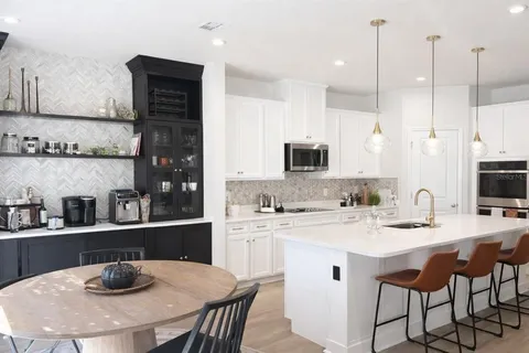 a kitchen with a sink a stove and chairs