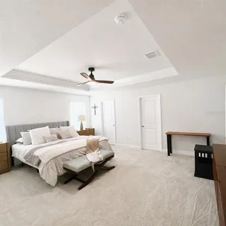a bedroom with a bed and a ceiling fan