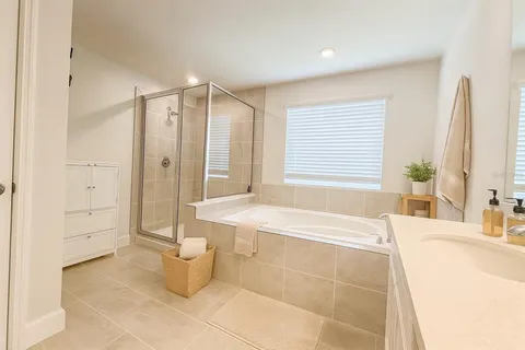 a spacious bathroom with a tub shower and sink