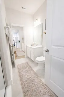 a spacious bathroom with a sink a toilet a mirror and shower