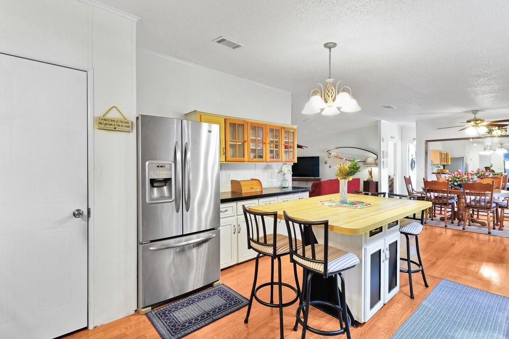7605 Cedar Bark Road Sebastian, FL 32976 - Photo 13 of 34 a kitchen with stainless steel appliances refrigerator dining table and chairs