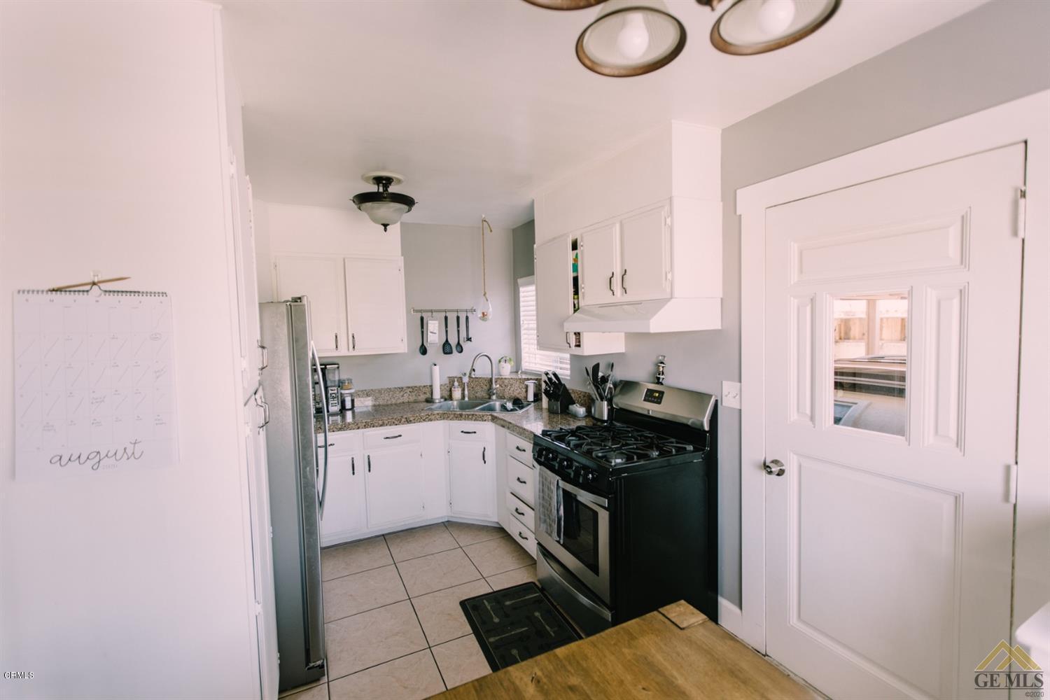 424 West Cedar Street Oxnard, CA 93033 - Photo 9 of 26 a kitchen with a stove a refrigerator and a sink