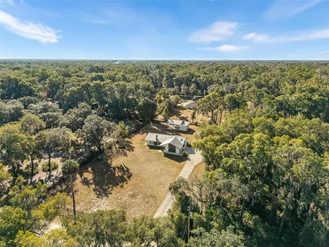 an aerial view of a house with a yard basket ball court and outdoor seating