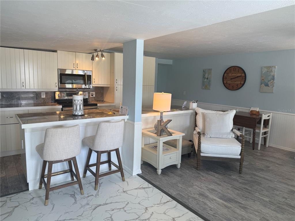 6190 Daffodil Road Venice, FL 34293 - Photo 3 of 16 a kitchen with a dining table chairs and white cabinets
