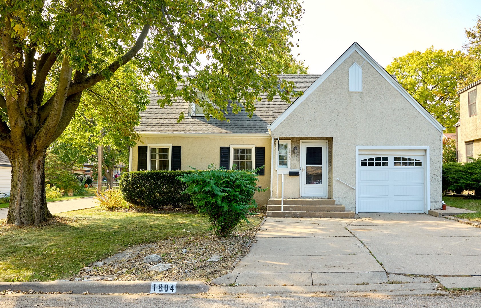 a front view of a house with a yard and potted plants