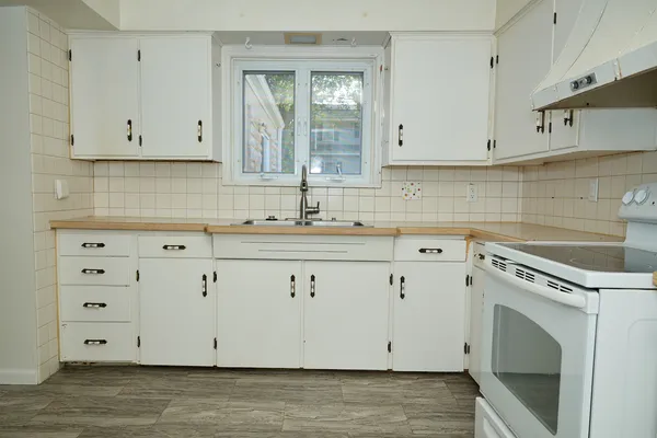 a view of a kitchen with white cabinets