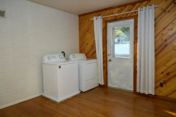 a storage room with wooden floor washer and dryer