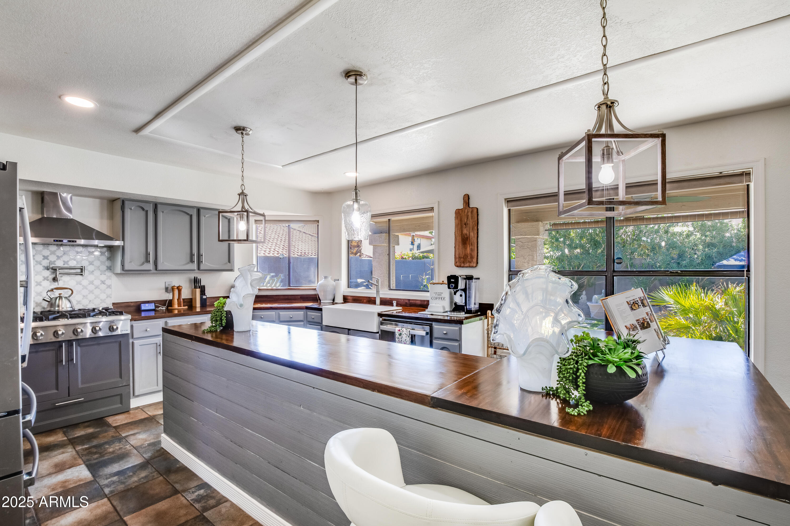 7383 West Utopia Road Glendale, AZ 85308 - Photo 2 of 18 a kitchen with a potted plant on the counter and cabinets
