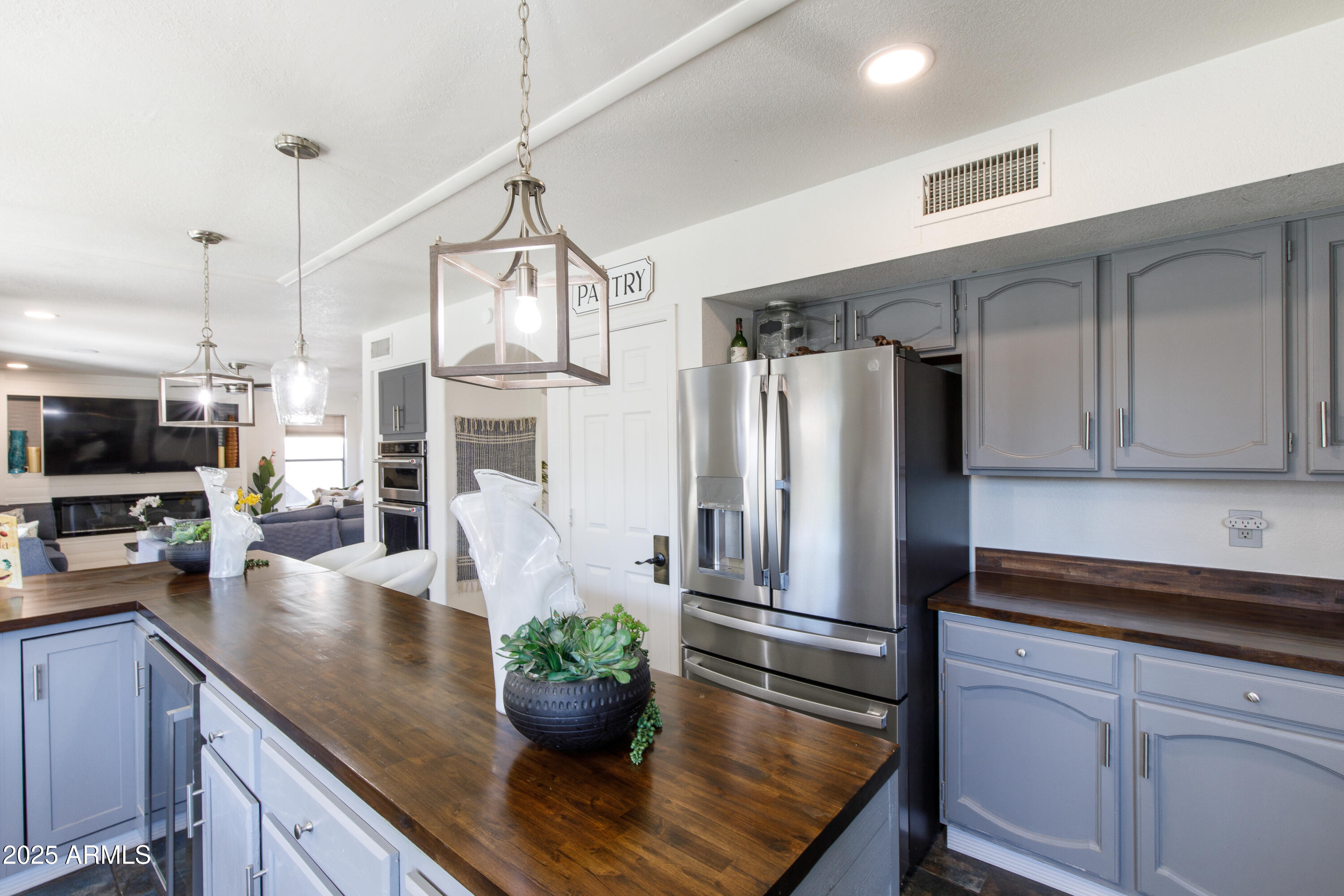 7383 West Utopia Road Glendale, AZ 85308 - Photo 9 of 18 a kitchen with stainless steel appliances granite countertop a refrigerator a stove and white cabinets with wooden floor