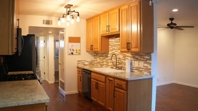 a bathroom with a granite countertop sink a mirror and shower