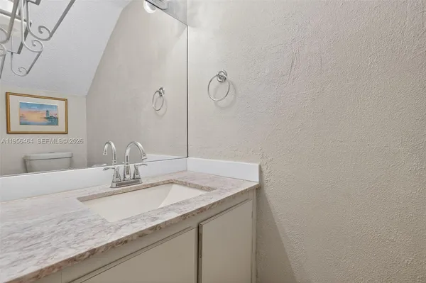 a bathroom with a granite countertop sink and a mirror