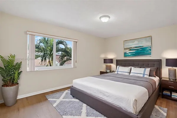 a bedroom with a large bed and a potted plant