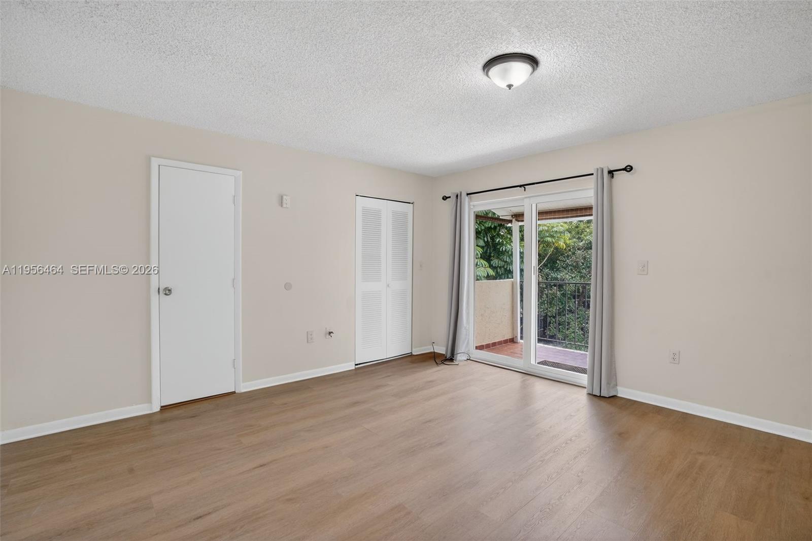 2455 Southwest 11th Street, Unit 7A Miami, FL 33135 - Photo 22 of 38 an empty room with wooden floor and windows