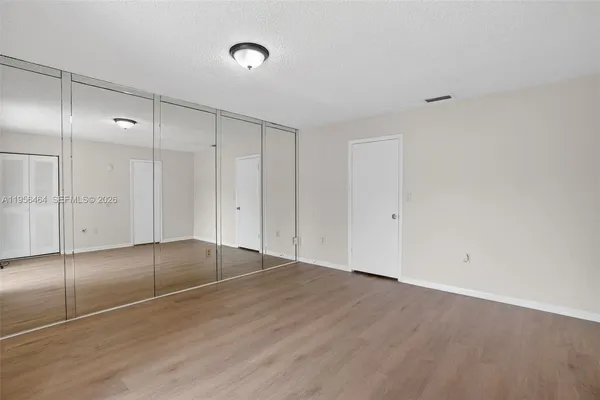 a view of an empty room with wooden floor