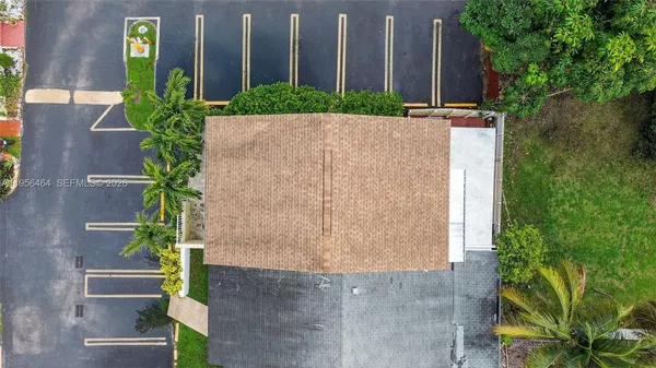 an aerial view of a house with a yard and large trees