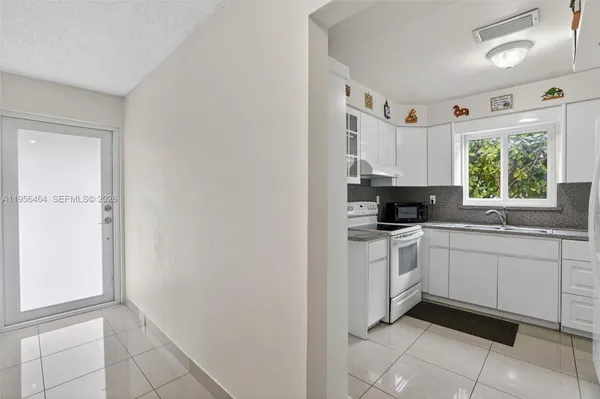 a kitchen with a white cabinets and window