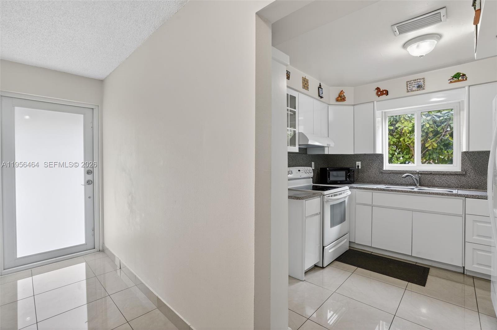 2455 Southwest 11th Street, Unit 7A Miami, FL 33135 - Photo 7 of 38 a kitchen with a white cabinets and window