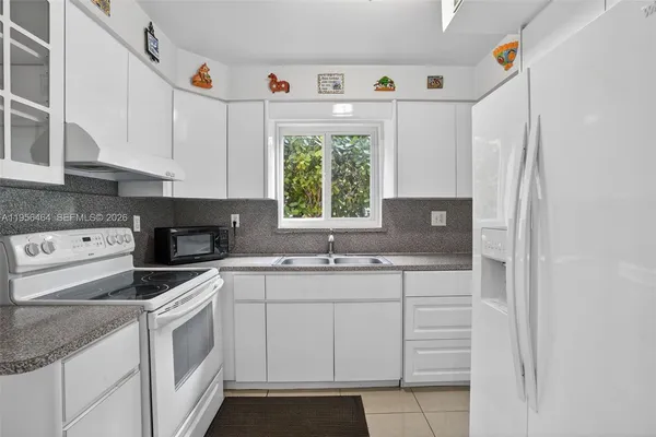a kitchen with white cabinets and white appliances