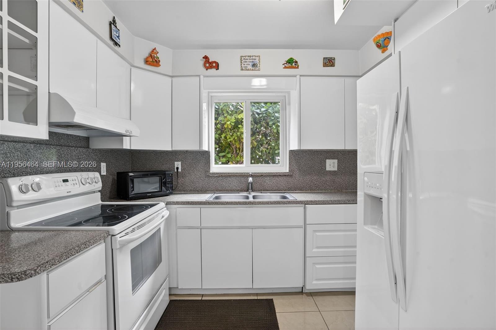 2455 Southwest 11th Street, Unit 7A Miami, FL 33135 - Photo 8 of 38 a kitchen with white cabinets and white appliances