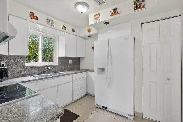 a kitchen with stainless steel appliances granite countertop a sink and a refrigerator