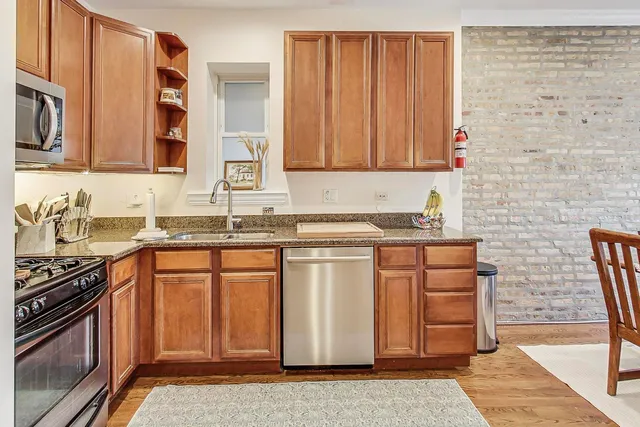 a kitchen with stainless steel appliances granite countertop a stove a sink and a microwave
