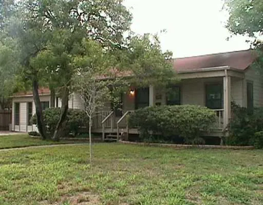 a view of a house with backyard and a tree