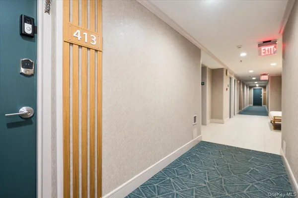 a view of a hallway with wooden floor and a bathroom
