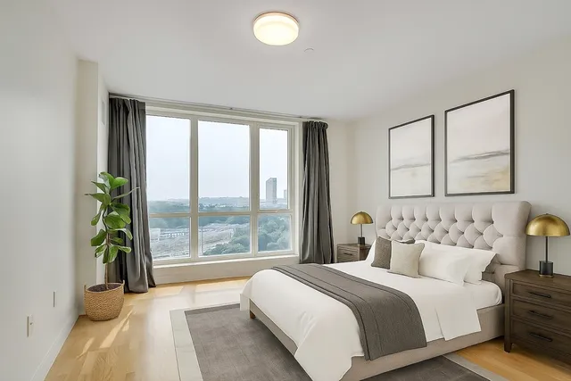 a bedroom with a bed and a large window