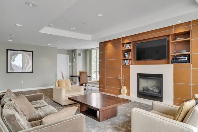 a living room with furniture a fireplace and flat screen tv