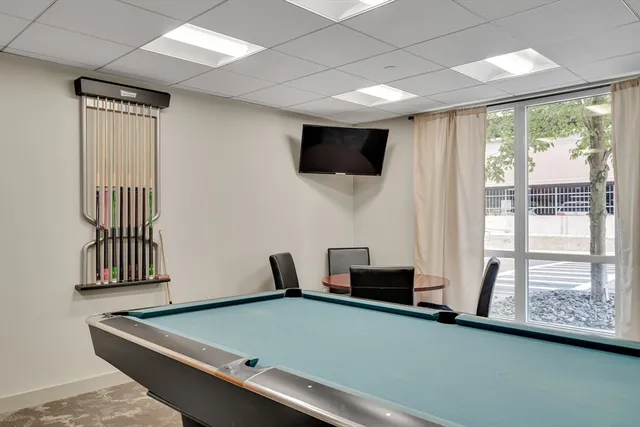 a room with pool table and windows