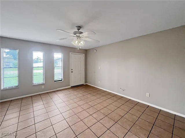 an empty room with windows and fan
