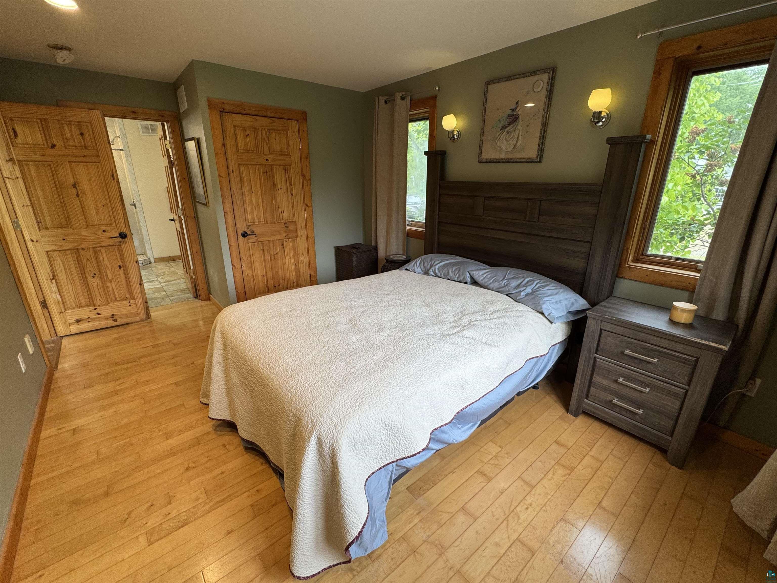 1745 Becks Road Maple, WI 54854 - Photo 19 of 46 Primary bedroom featuring natural wood-finish flooring. Includes walk in closet with bathroom ensuite.