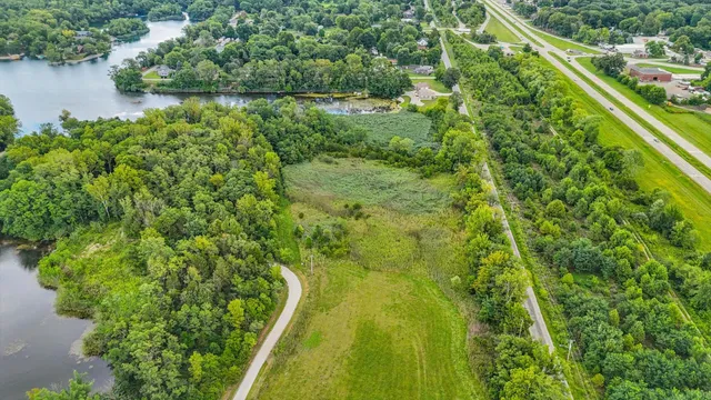 a view of a yard with plants and a lake view