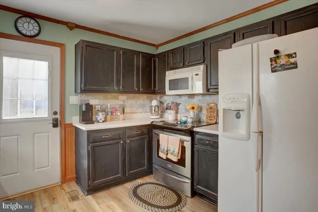 a kitchen with stainless steel appliances granite countertop a refrigerator sink stove and microwave