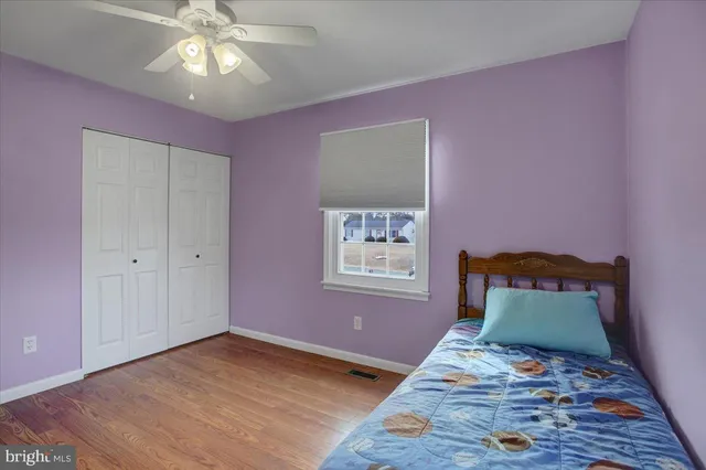 a view of a livingroom with wooden floor and a ceiling fan