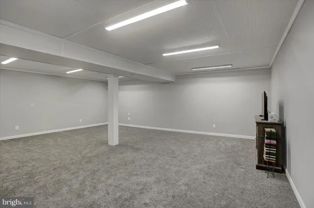 an empty room with furniture and a flat screen tv