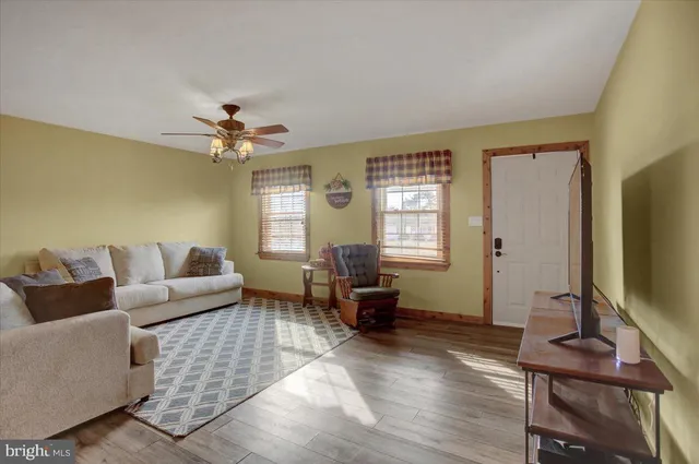 a living room with furniture a window and a flat screen tv
