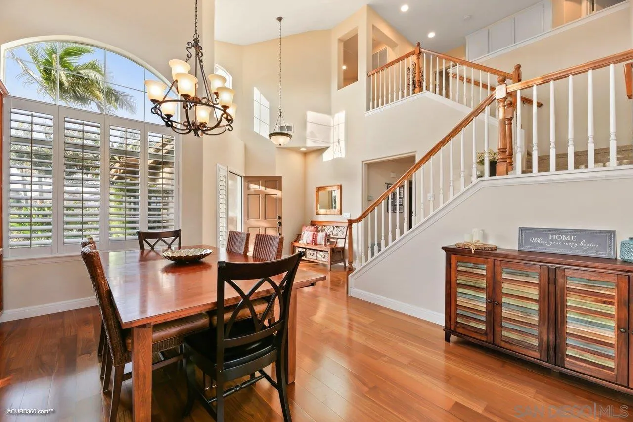 12504 Eclipse Place San Diego, CA 92129 - Photo 19 of 60 a view of a dining room with furniture wooden floor and chandelier