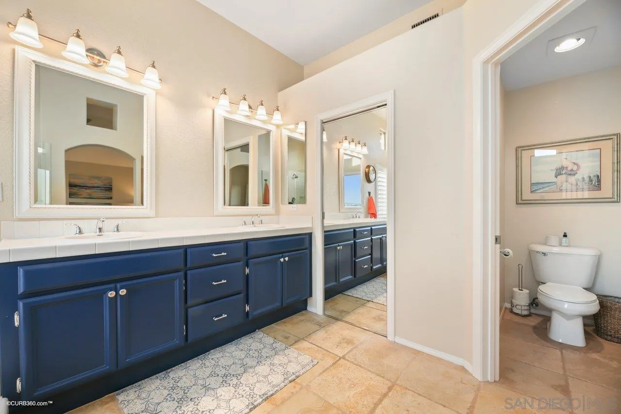12504 Eclipse Place San Diego, CA 92129 - Photo 40 of 60 a spacious bathroom with a double vanity sink toilet and a mirror