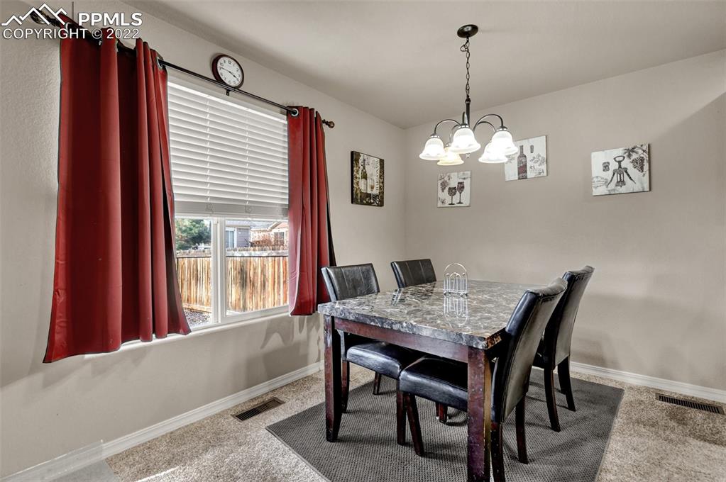 6570 Gelbvieh Road Peyton, CO 80831 - Photo 12 of 38 a view of a dining room with furniture window and wooden floor