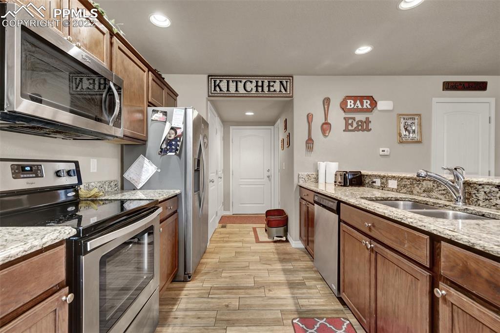 6570 Gelbvieh Road Peyton, CO 80831 - Photo 14 of 38 a kitchen with stainless steel appliances granite countertop a stove and a sink